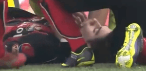 Molina lies unconscious on the pitch surrounded by teammates  (Image from YouTube)