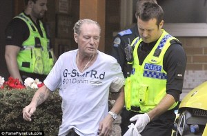 On the edge - Gascoigne is helped into an ambulance after being found slumped outside his home  (Image from FameFlynet)
